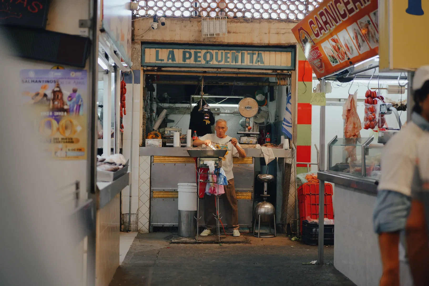 Comerciante atendiendo un puesto de alimentos en un mercado mexicano